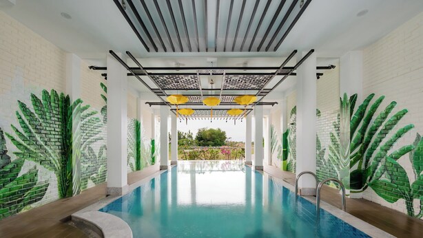 An indoor swimming pool with a clear view of the pool, surrounded by walls with green leaf patterns. - Welcome Old Town Hotel (Da Nang)