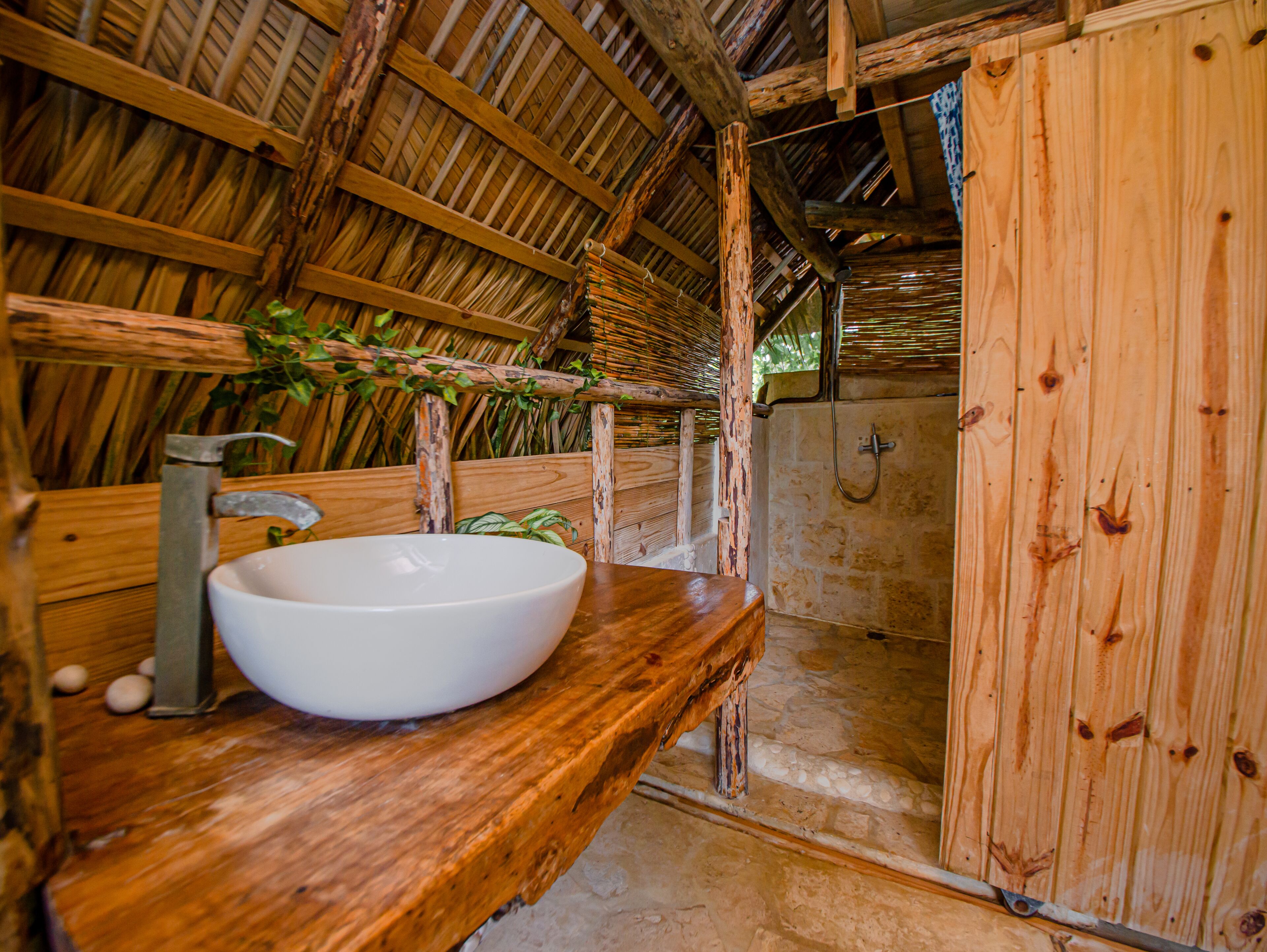 A rustic bathroom with a wooden sink and a shower.