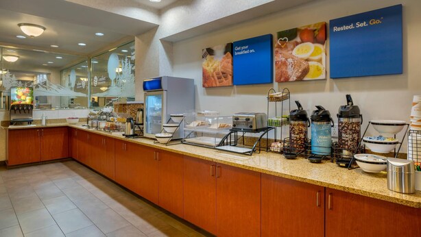 A breakfast bar with a coffee machine, toaster, and various food containers. - Comfort Inn & Suites Salem Northeast (Salem)