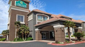 A La Quinta Inn & Suites building with a prominent sign, a covered entrance, and palm trees. - La Quinta Inn & Suites by Wyndham Manteca - Ripon (Ripon)