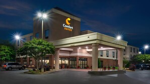 Un hotel Comfort Suites con un diseño moderno, que presenta una entrada destacada y una fachada bien iluminada.