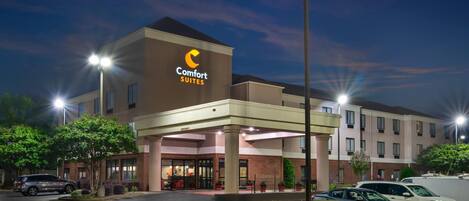 Un hotel Comfort Suites con diseño moderno, que cuenta con una entrada destacada y un estacionamiento cubierto.