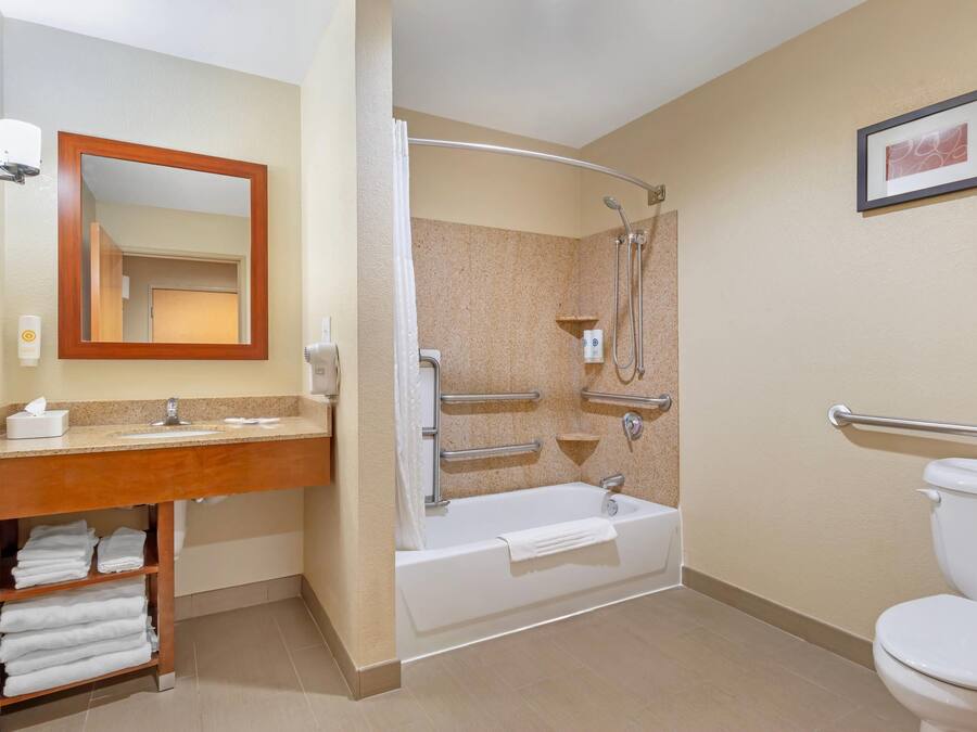 Une salle de bain comprenant un meuble-lavabo, un évier, un miroir, une douche et des toilettes.