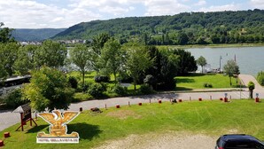 A hotel with a view of a lake and hills.