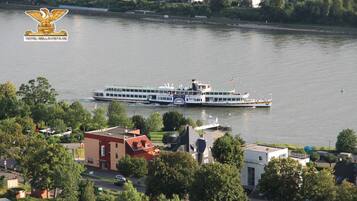 A riverboat docked near a town with buildings and trees.