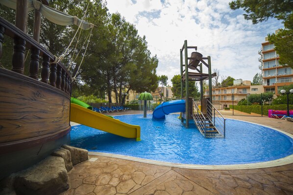 Uma piscina com toboáguas e área de recreação com tema náutico.