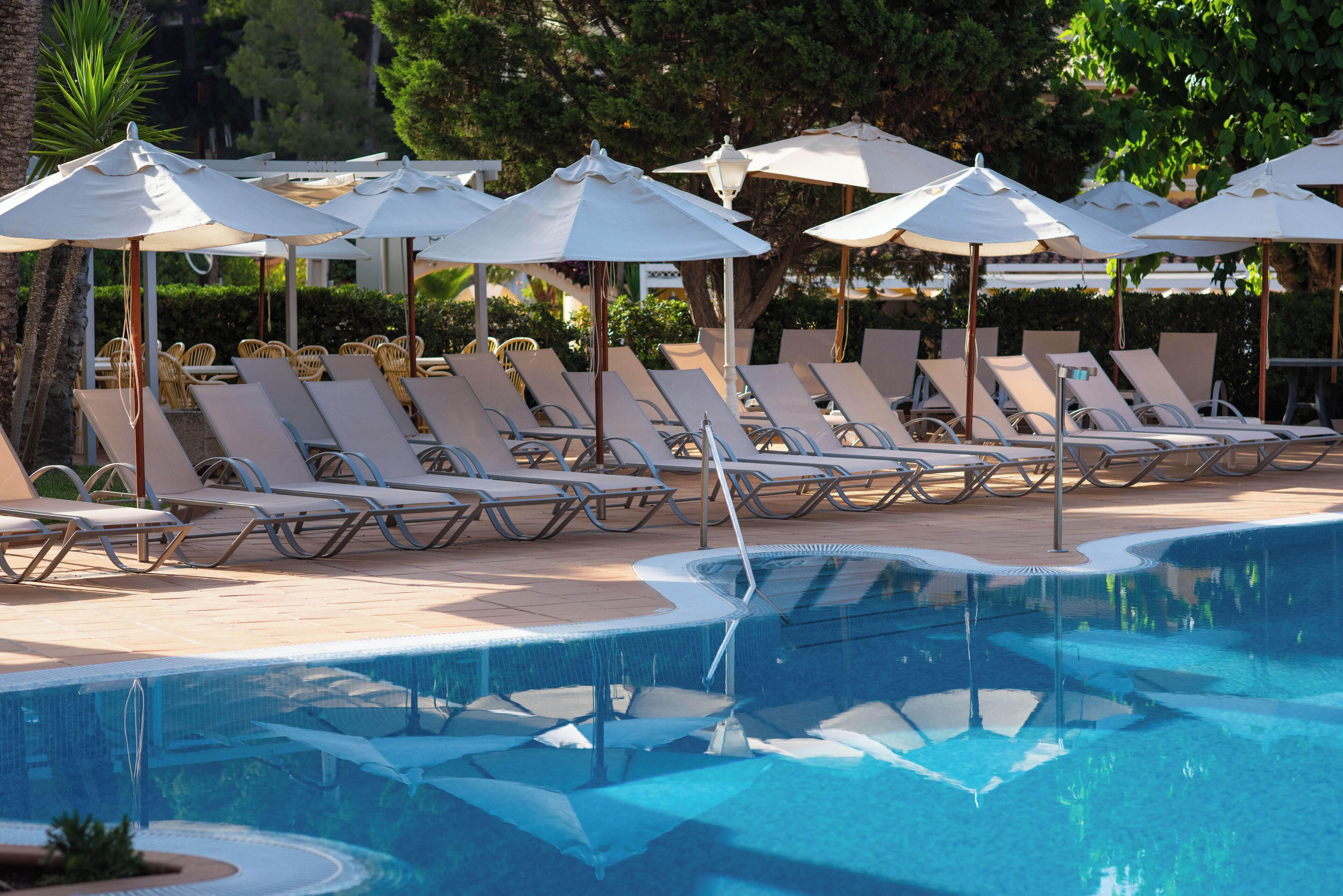 A poolside area with lounge chairs and umbrellas.