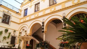 A courtyard with a fountain, arches, potted plants, and a staircase. - Cortijo el Esparragal (Gerena)