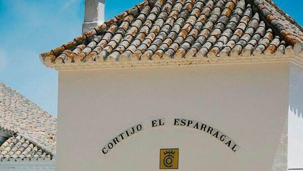 A building with a sign reading 'CORTIJO EL ESPARRAGAL' and an archway entrance. - Cortijo el Esparragal (Gerena)