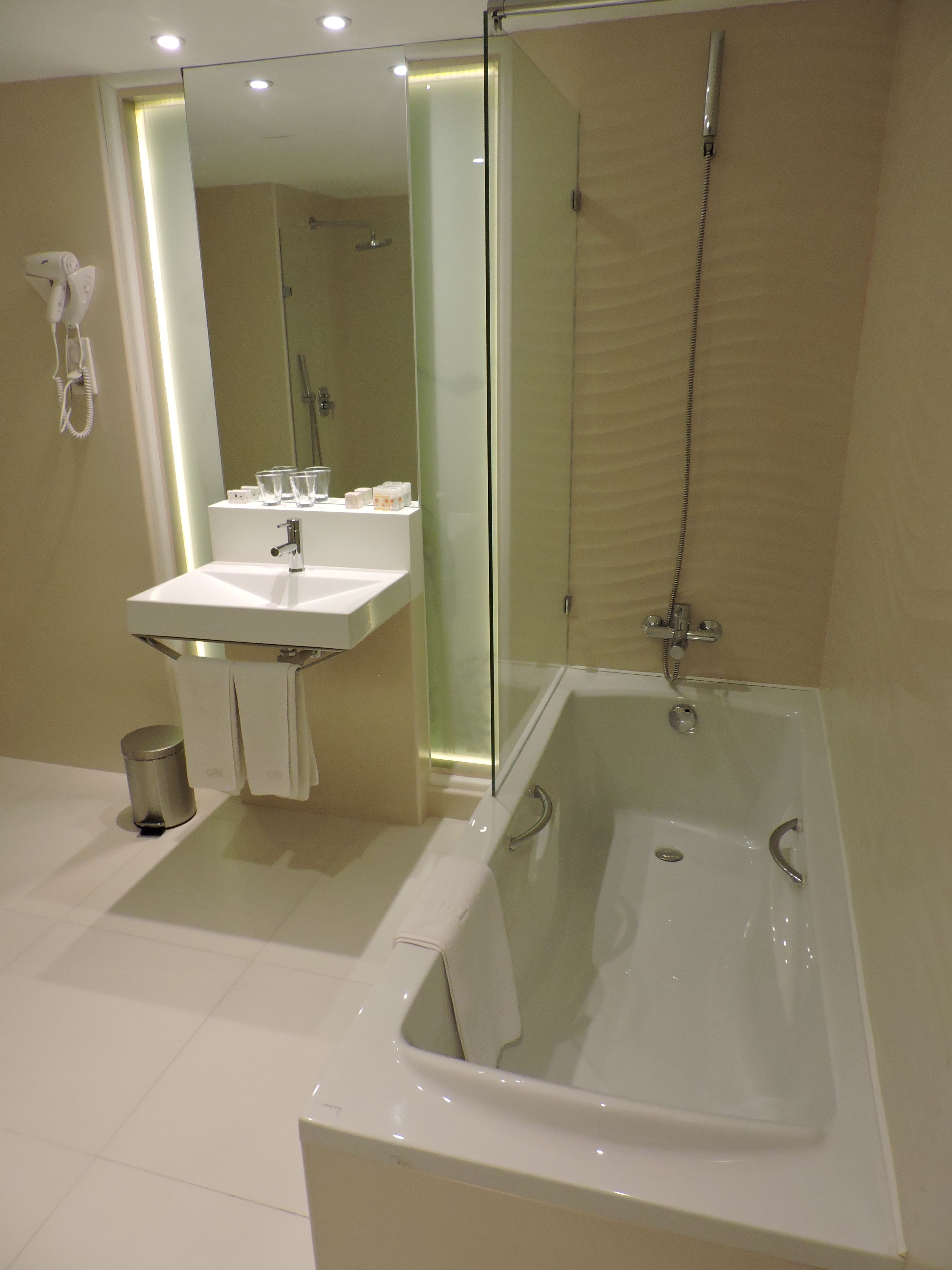 A modern bathroom with a glass-enclosed shower, a white sink, and a toilet.