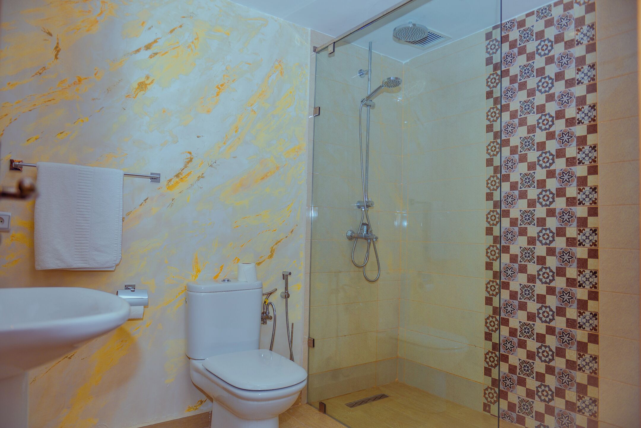 A bathroom with a toilet, sink, and shower.