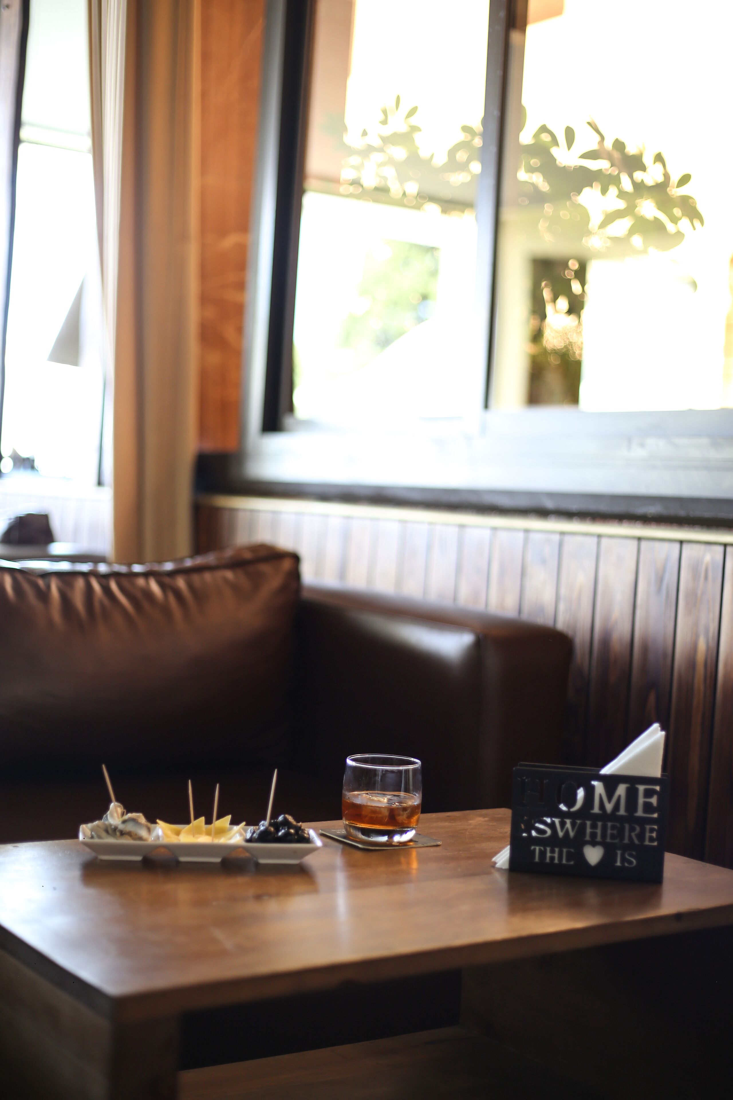 Una mesa de madera con un vaso de whisky, una caja con la inscripción 