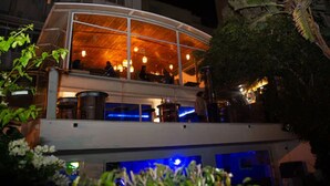A two-story building with a glass facade, outdoor seating area, and a pool. - Hotel Rembrandt (Tangier)