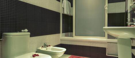 A bathroom with a toilet, bidet, and sink.