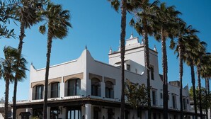 A white building with a symmetrical facade, multiple windows, and a central tower. - Hotel La Malvasía by Kaizen Hoteles (Almonte)
