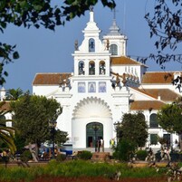 Igreja branca com uma torre de sino e uma grande entrada em arco.