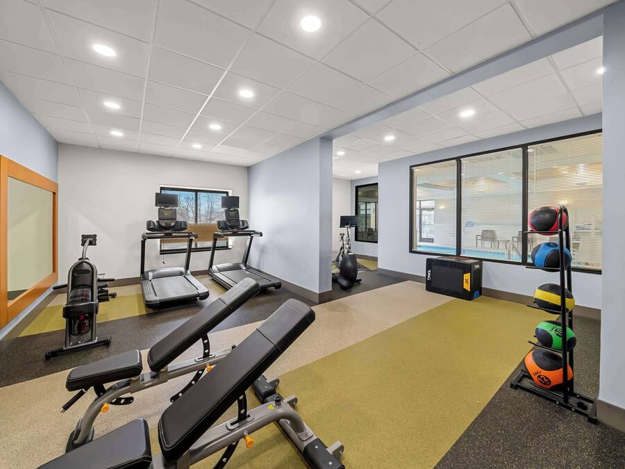 A gym with exercise equipment, including treadmills, a stationary bike, and weightlifting stations.