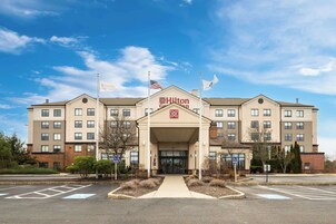 Un hotel grande de varios pisos con un letrero llamativo de Hilton Garden Inn.