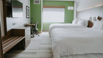 Una habitación de hotel con una cama, un escritorio, una silla, un televisor y una ventana.