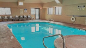 An indoor swimming pool with clear water, a lifeguard sign, and a set of lounge chairs. - Holiday Inn Express & Suites South - Lincoln by IHG (Lincoln)