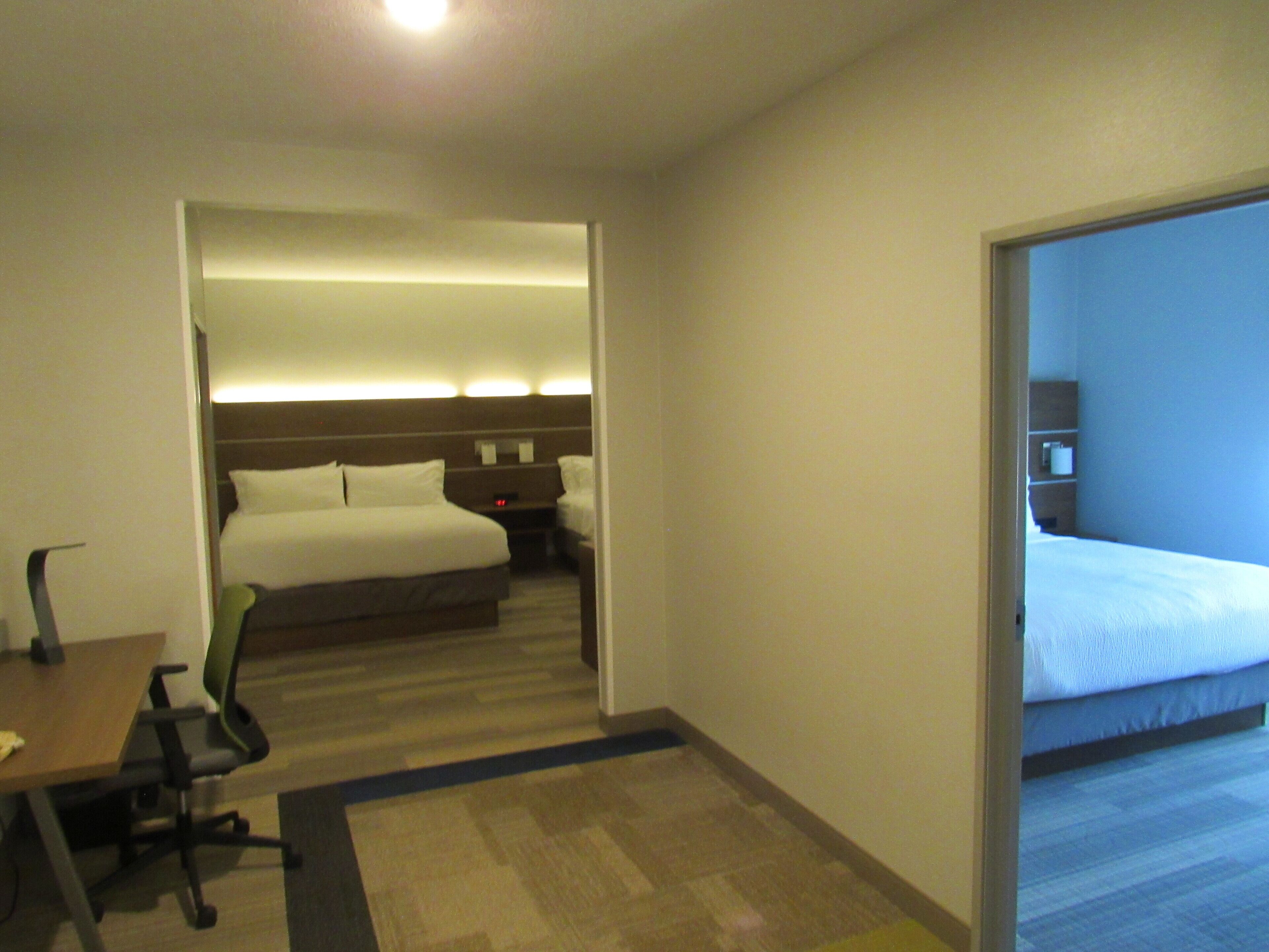 A hotel room with a bed, a desk, and a chair.