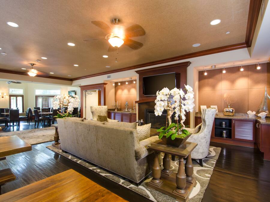 A spacious living area with a sofa, dining tables, and a fireplace.