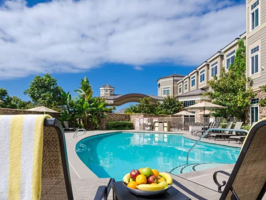 A poolside area with lounge chairs and a bowl of fruit.