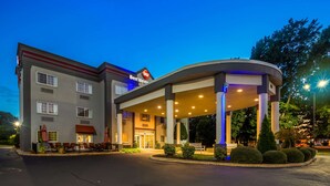 Un hotel Best Western con entrada cubierta, asientos exteriores y una zona ajardinada.