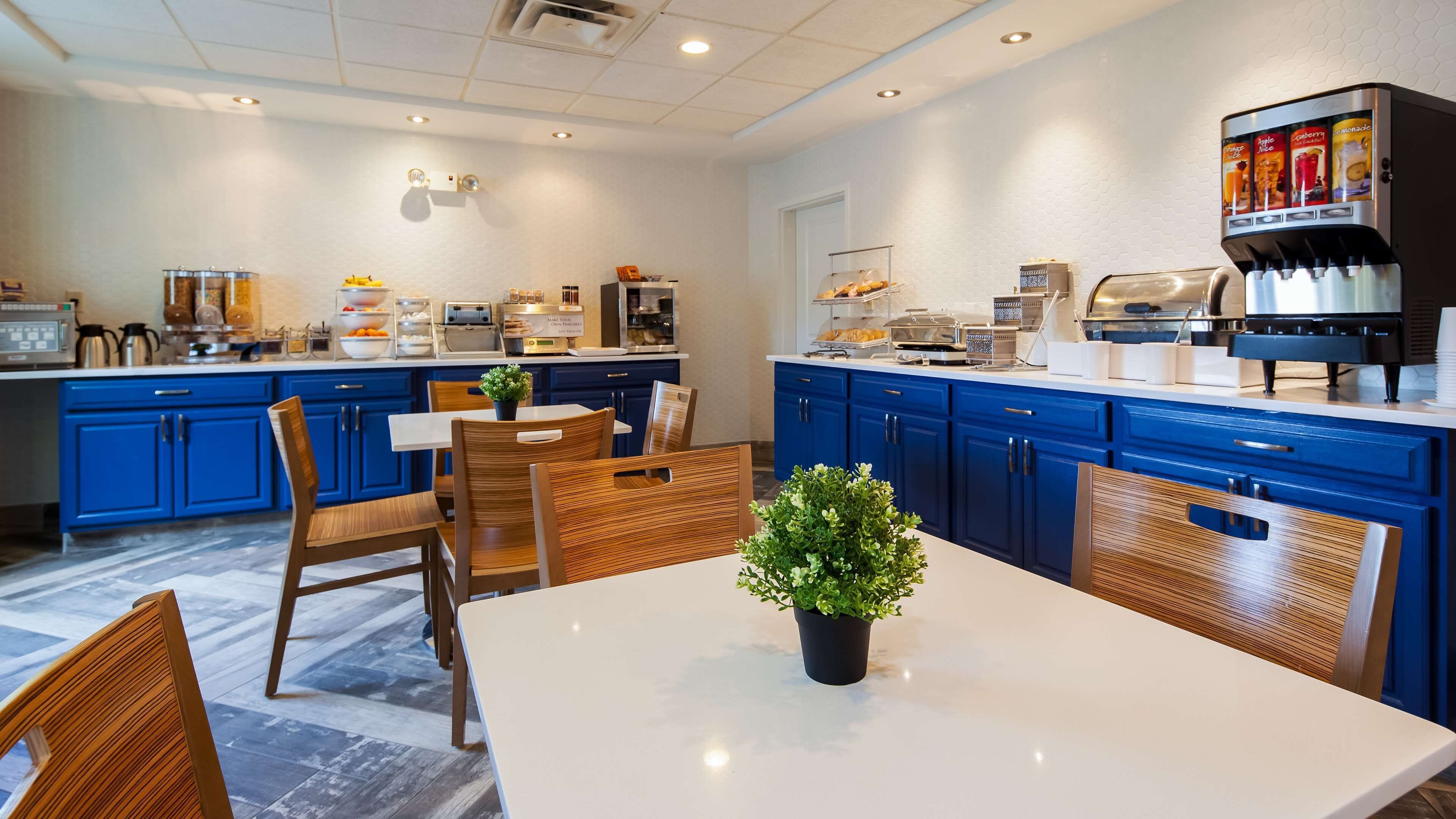 Una cocina moderna con armarios azules, encimera blanca y una cafetera.