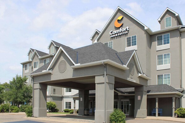 Edificio de Comfort Inn & Suites con entrada cubierta, varias ventanas y cielo despejado.