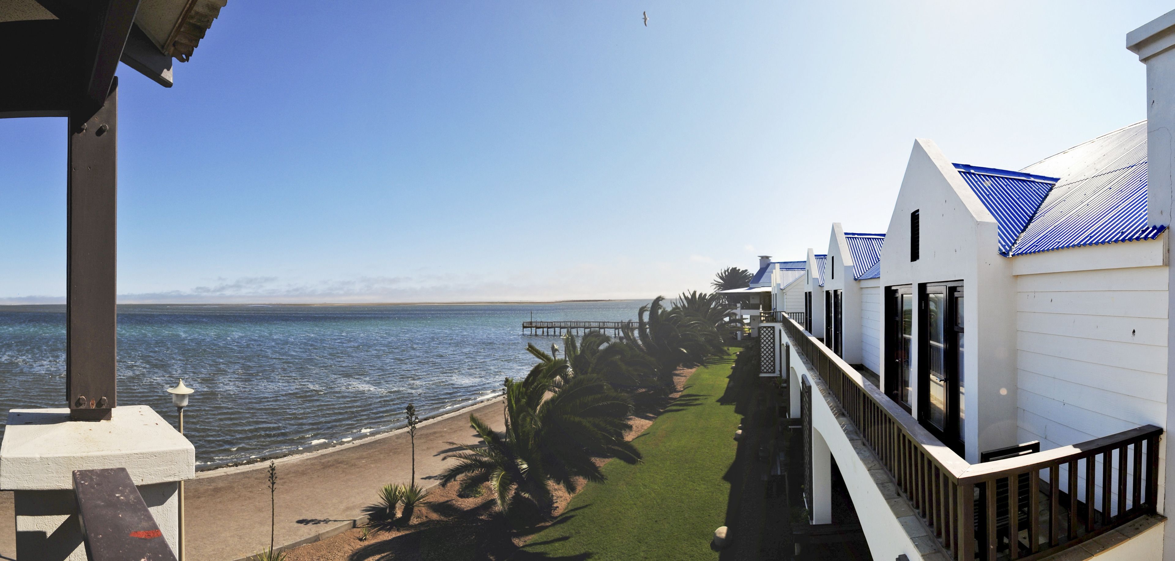 Un hotel frente al mar con un edificio largo y estrecho con vistas al océano.