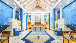 A lobby with a central reception desk, blue patterned walls, wooden flooring, and seating areas. - Protea Hotel by Marriott Walvis Bay Pelican Bay (Walvis Bay)