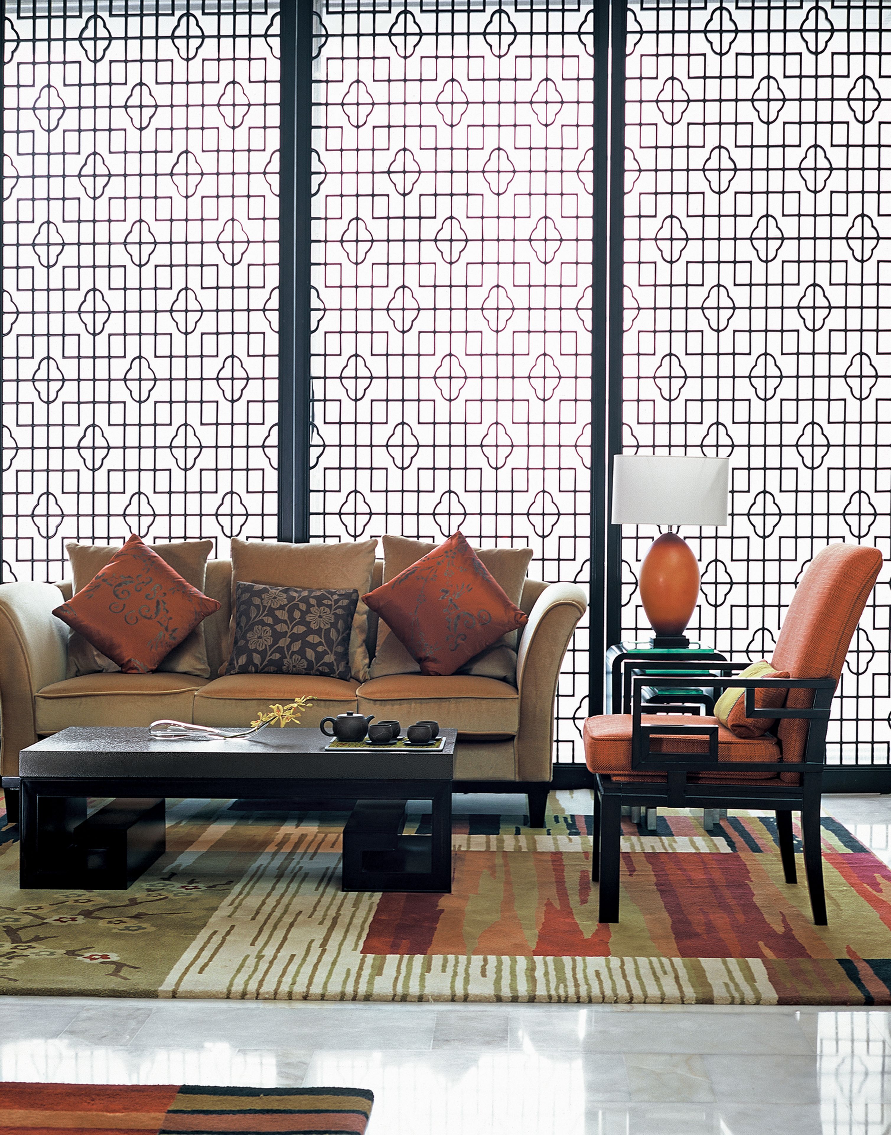 Uma sala de estar moderna com um sofá, poltronas, uma mesa de centro e um abajur.