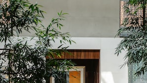 Un hall d’entrée spacieux, doté de canapés en cuir, d’un piano et d’une grande plante.