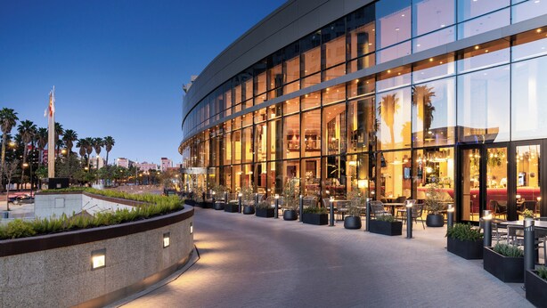 A modern building with a glass facade, outdoor seating area, and a well-lit entrance. - Melia Valencia (Valencia)
