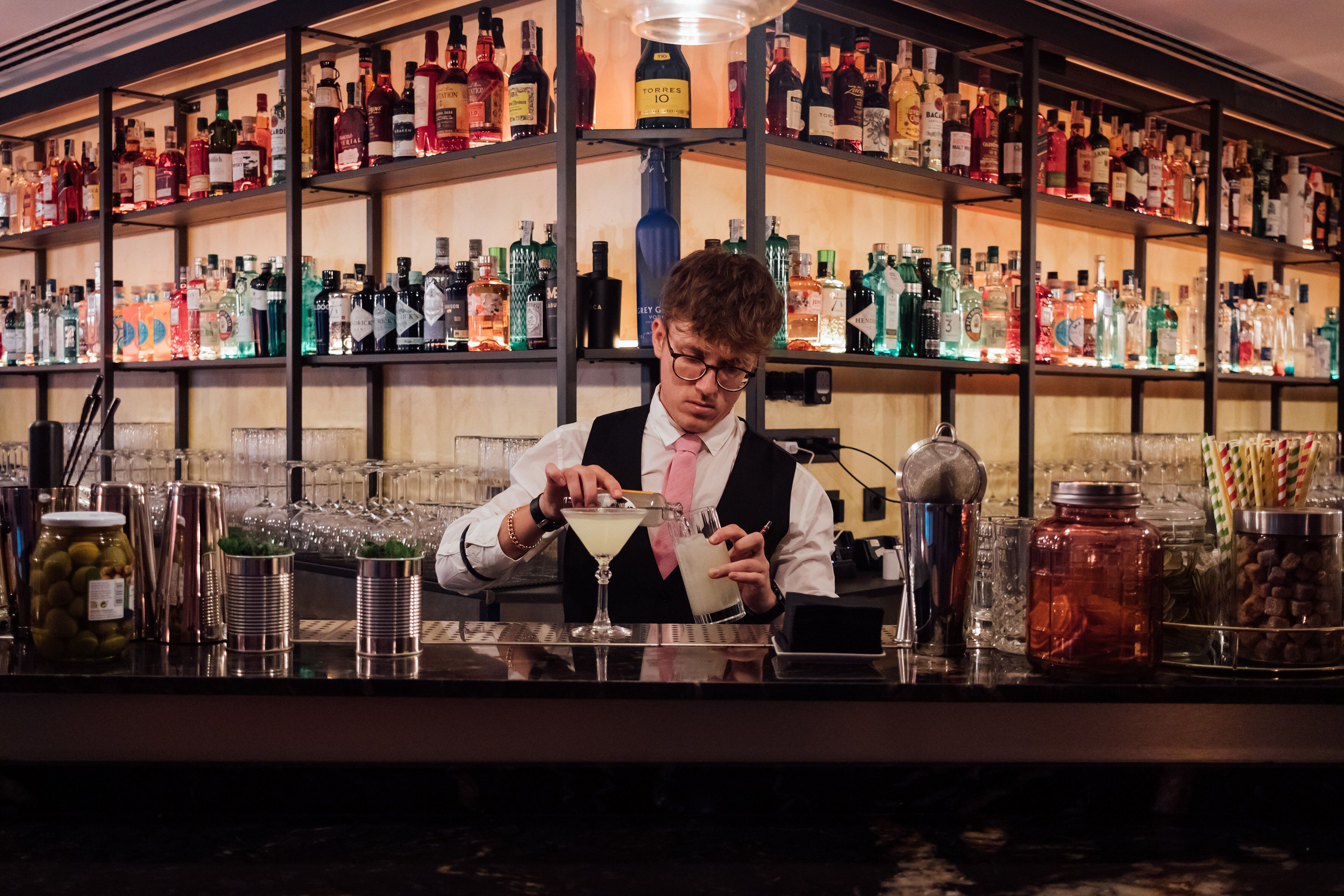 Eine Bar mit Regalen voller verschiedener Flaschen und Gläser.
