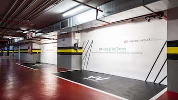 A modern, clean parking garage with white walls and black and yellow stripes.
