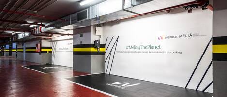 A modern, clean parking garage with white walls and black and yellow stripes.