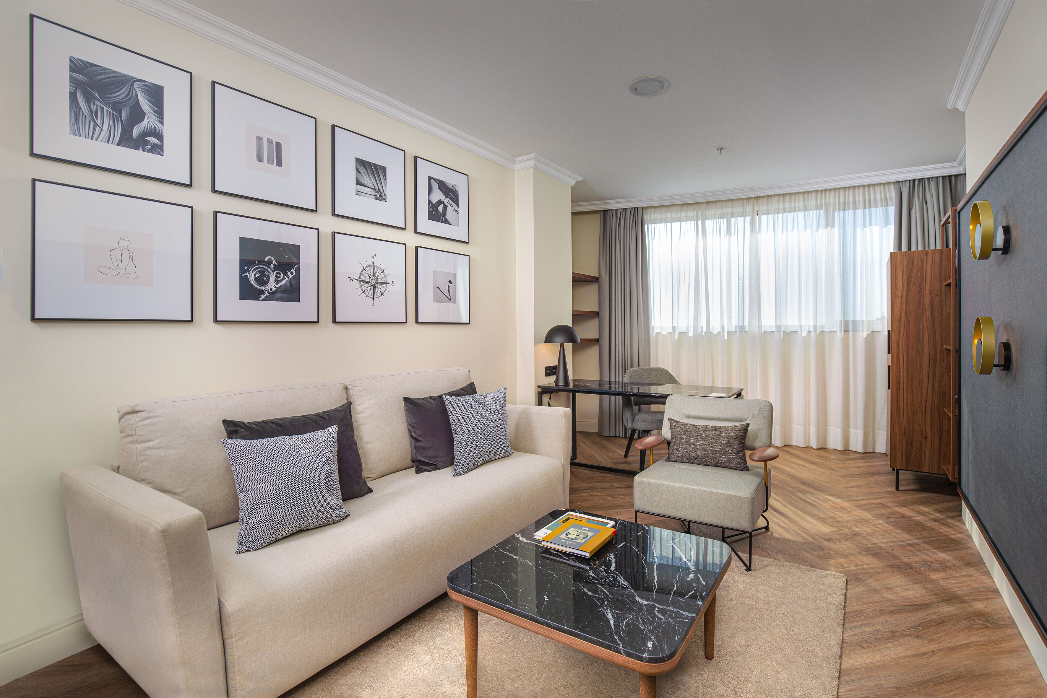 A modern living room with a sofa, armchairs, a coffee table, and artwork on the wall.
