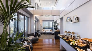 Una cocina moderna con barra desayunadora, piso de madera y grandes ventanales con vistas al exterior.