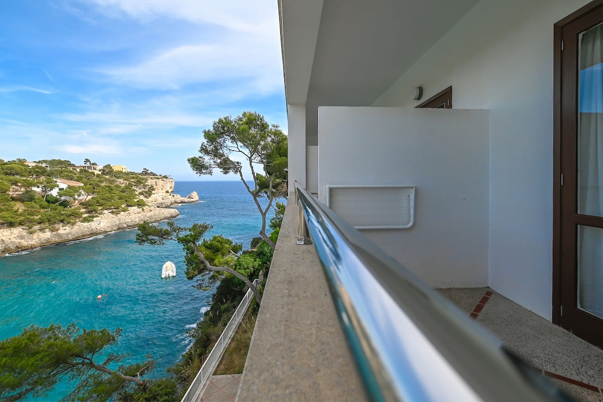 A balcony with a view of the sea and a coastal landscape.