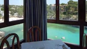 Une chambre d’hôtel dotée d’une grande fenêtre donnant sur une zone côtière.