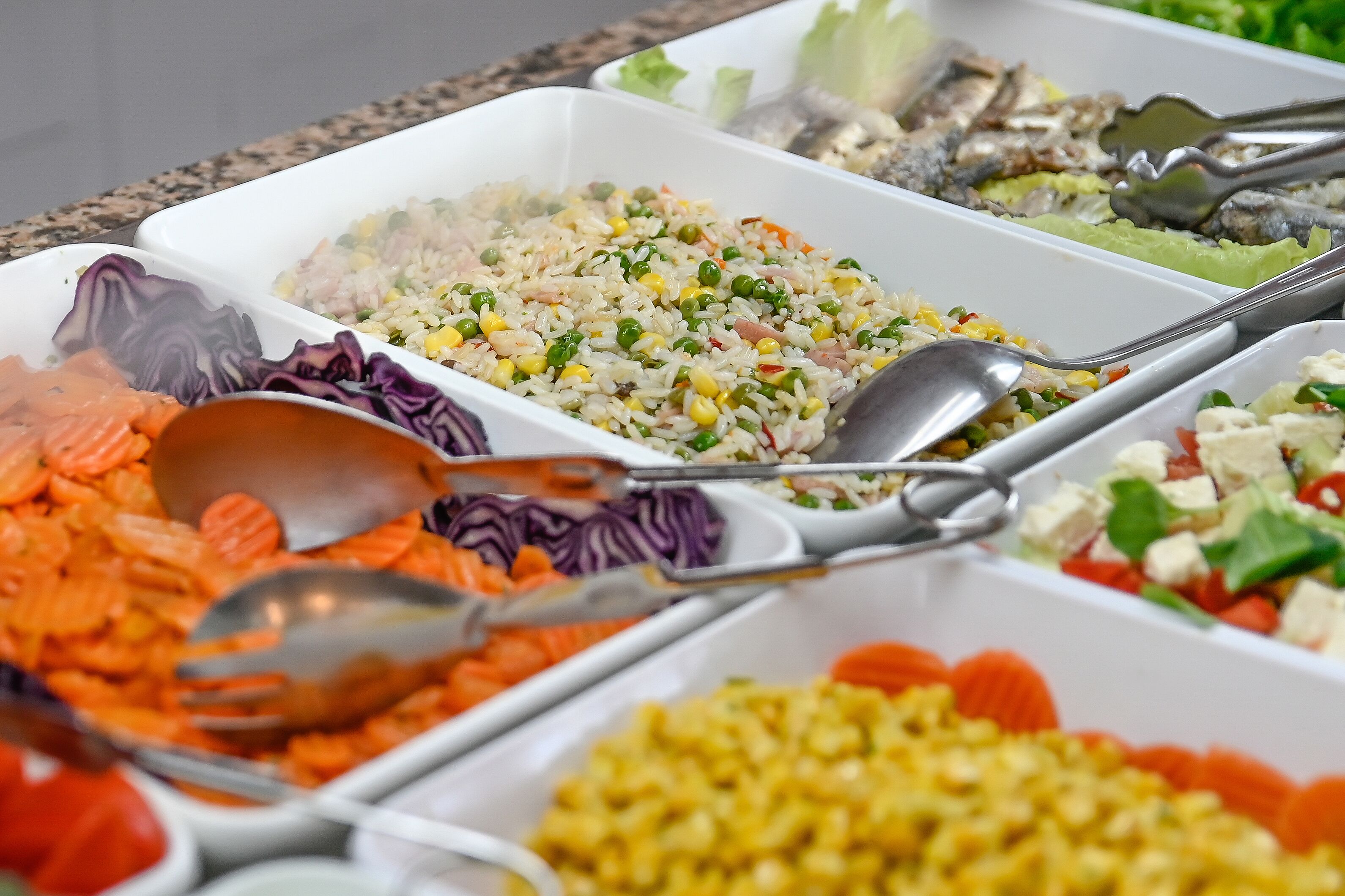 A buffet with various dishes including rice, vegetables, and seafood.
