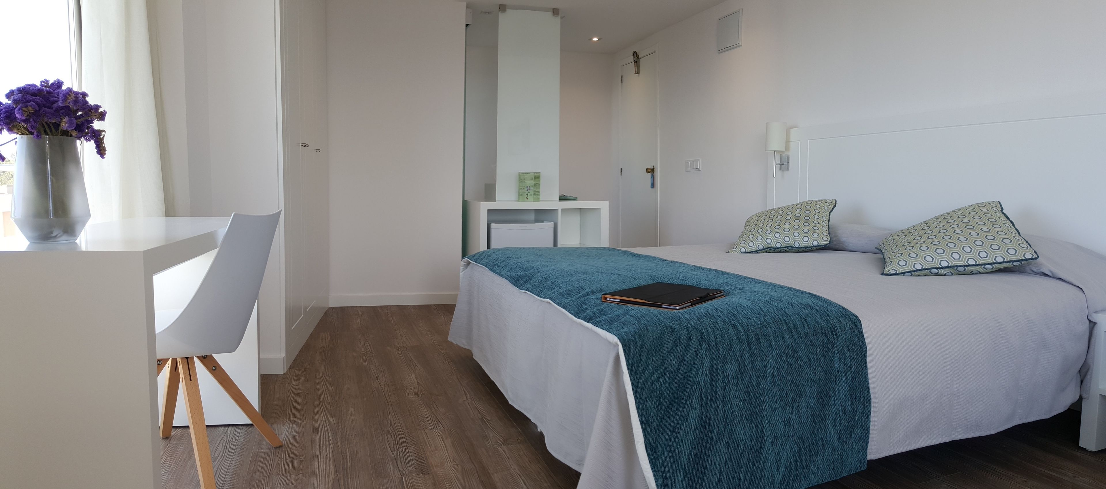 A modern bedroom with a bed, a desk, and a chair.