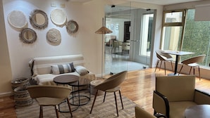 A modern living room with a sofa, chairs, a coffee table, and decorative mirrors on the wall. - Kenton Palace Bariloche (San Carlos de Bariloche)