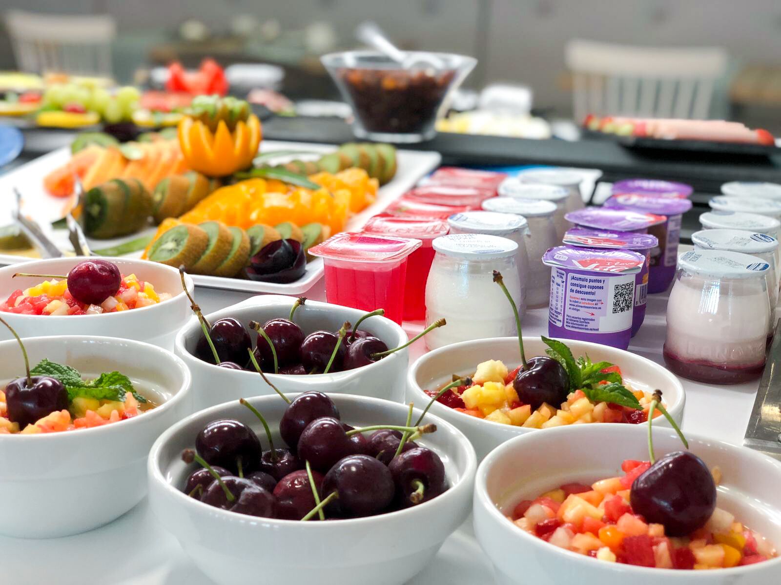 Un bufé con diversas opciones de comida, incluyendo frutas, verduras y productos lácteos.