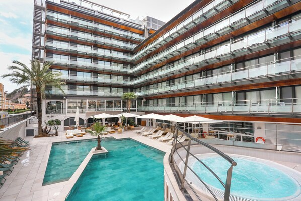 A modern hotel with a rooftop pool, multiple balconies, and outdoor seating areas. - KAKTUS Hotel Kaktus Playa (Calella)