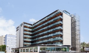 A modern hotel with multiple balconies, a glass facade, and a clear sky. - KAKTUS Hotel Kaktus Playa (Calella)