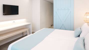 Een moderne slaapkamer met een bed, een aan de muur bevestigde televisie, een bankje en een deur.
