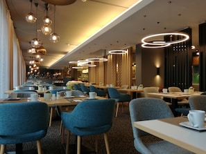 A modern restaurant with multiple dining tables and chairs, ambient lighting, and a view of the city. - Holiday Inn Salzburg City by IHG (Salzburg)